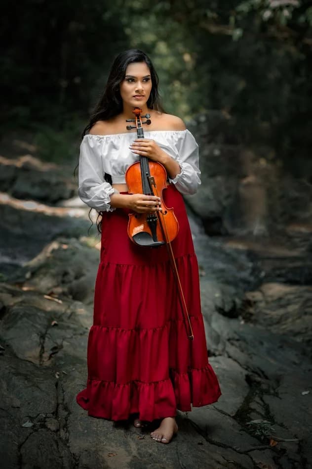 ස්වාභාවික පරිසරයක වයලීනයක් අතැති කාන්තාවක්