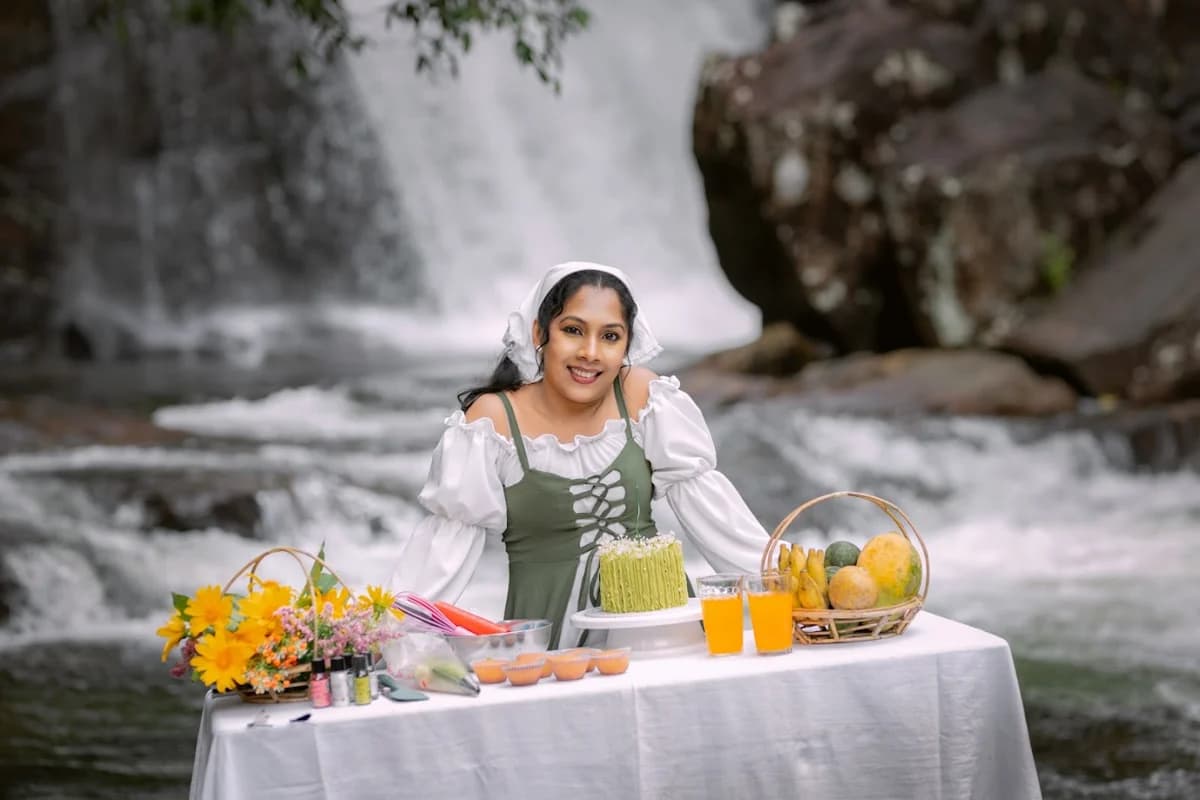 දිය ඇල්ලක් අසල සැමරුම් මේසයක සිටින කාන්තාවක්